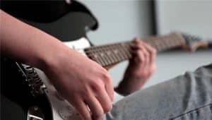 Closeup of hands playing an electric guitar